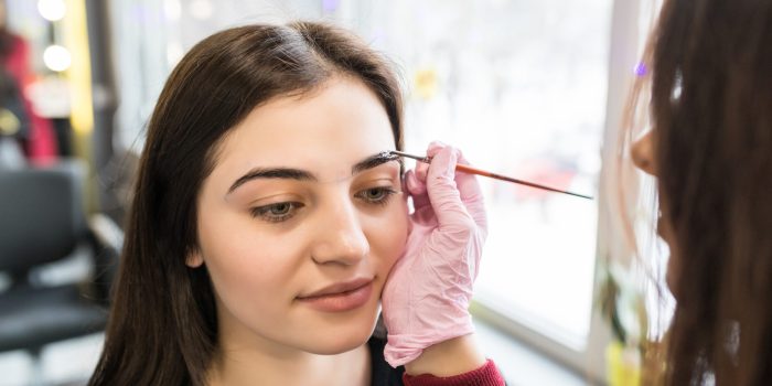 model is doing eyebrow painting procedure